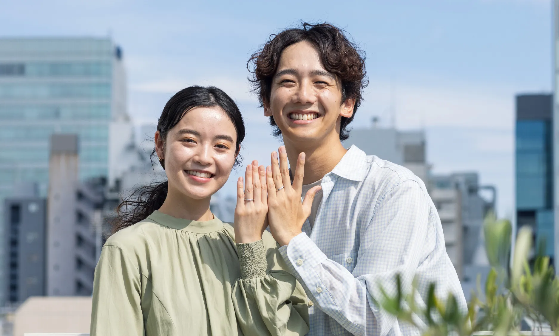 2人の男女が指輪を笑顔ではめている様子