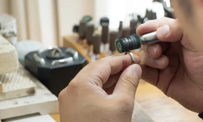 職人が工具を使って指輪を研磨している様子