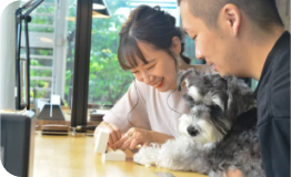 犬を抱きながら指輪作りを楽しむカップル