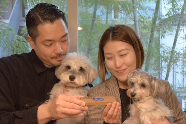 タグを手に2匹の愛犬と記念撮影するおふたり