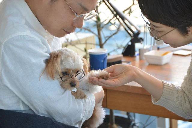 愛犬を抱いて指輪づくりをする様子